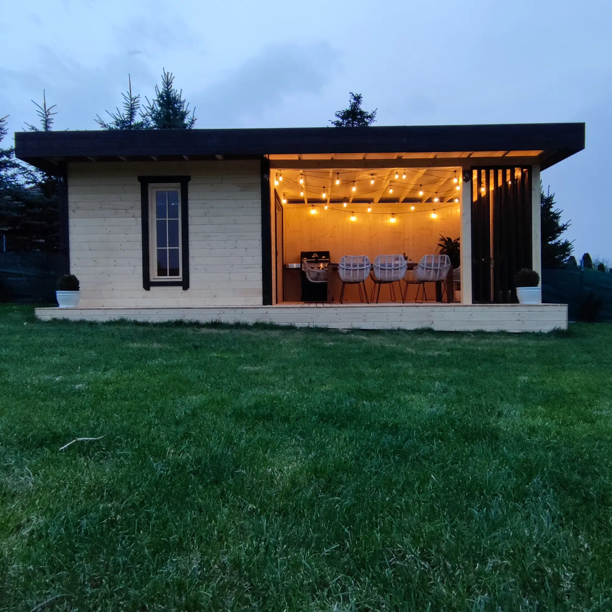 Altanka ogrodowa z drewna obok domku narzędziowego