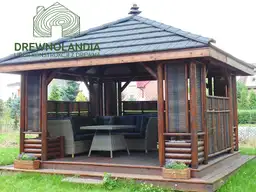 altana ogrodowa z kanapa i krzeslami wewnątrz