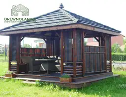 ciemna altana ogrodowa z kanapa stolem i krzeslami