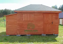 mały domek letniskowy na trawie z dachem ciemnym