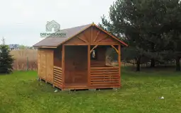 mały domek letniskowy z małym tarasem i bordowym dachem