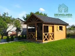 maly domek na trawie z dachem ciemnym i malym tarasem