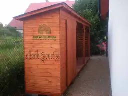 drewutnia stojąca przy płocie z ciemnym dachem