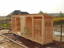 jasna pergola stojąca przy czarnym płocie