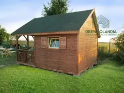 brazowy domek letniskowy z ciemnym dachem, tarasem, stojacy przy plocie