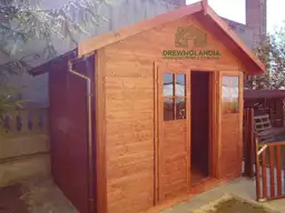 mały domek letniskowy stojący przy domu z otwartymi drzwiami