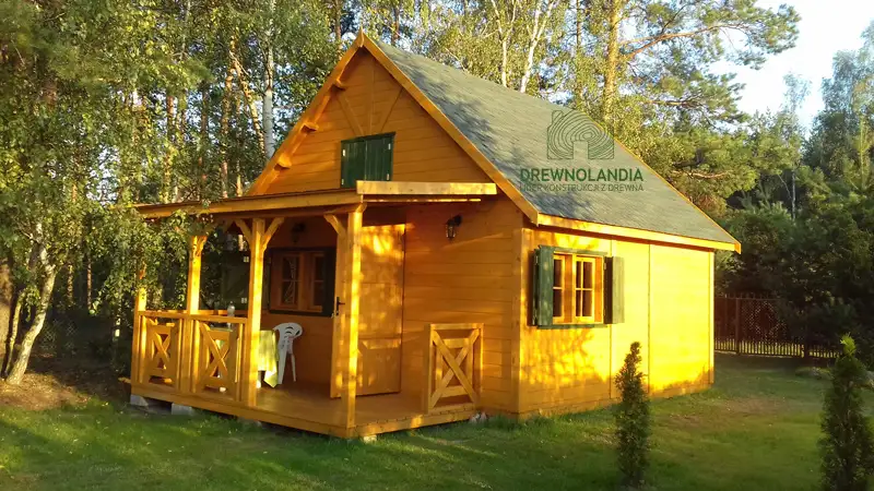 jasnobrązowy piętrowy domek letniskowy stojący na trawie