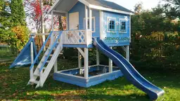 niebieski domek letniskowy ze zjeżdżalnią dla dzieci z ciemnym dachem