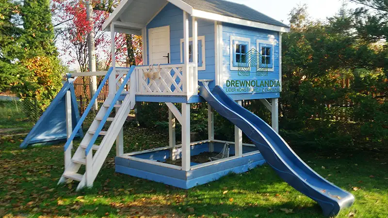 niebieski domek letniskowy ze zjeżdżalnią dla dzieci z ciemnym dachem