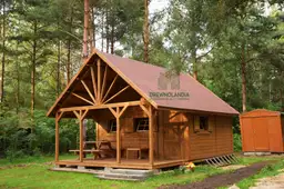 domek letniskowy z tarasem stojący w lesie