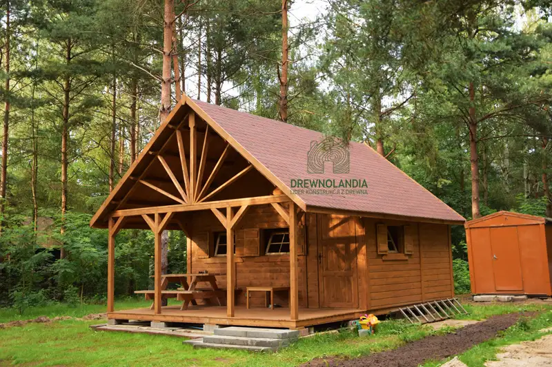 domek letniskowy z tarasem stojący w lesie