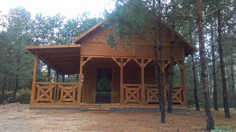 duży domek letniskowy z werandą i gankiem w lesie