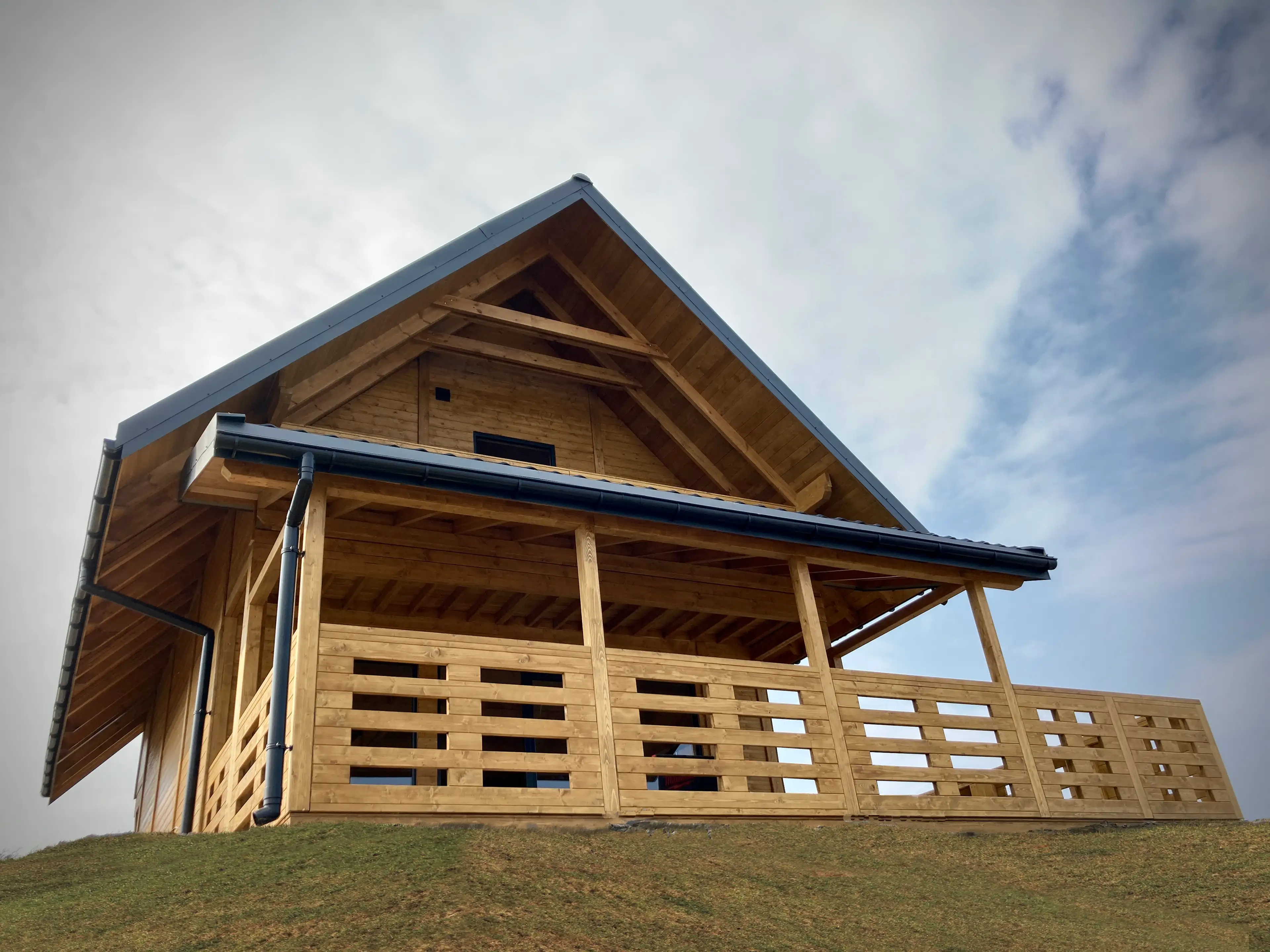 drewniany domek letniskowy z poddaszem i balkonem