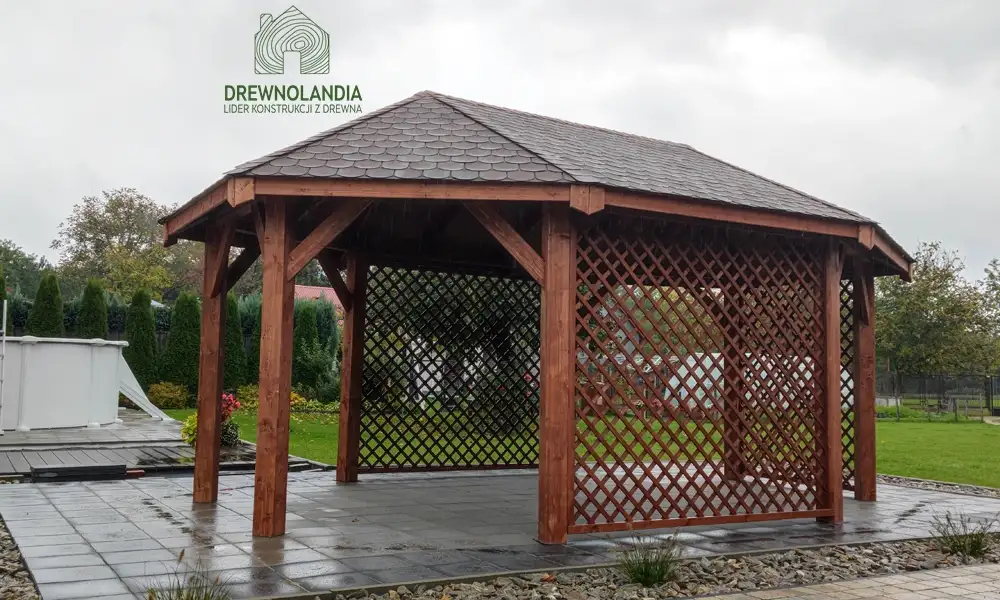 Drewniana owalna wiata ogrodowa Monika, o wymiarach 3,5x5,5 m, wykonana przez Drewnolandię