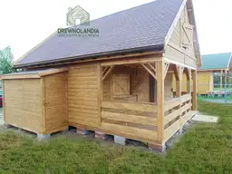 brazowy domek letniskowy z ciemnym dachem na trawie