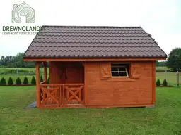 mały domek letniskowy na trawie brązowy z kafelkami na dachu